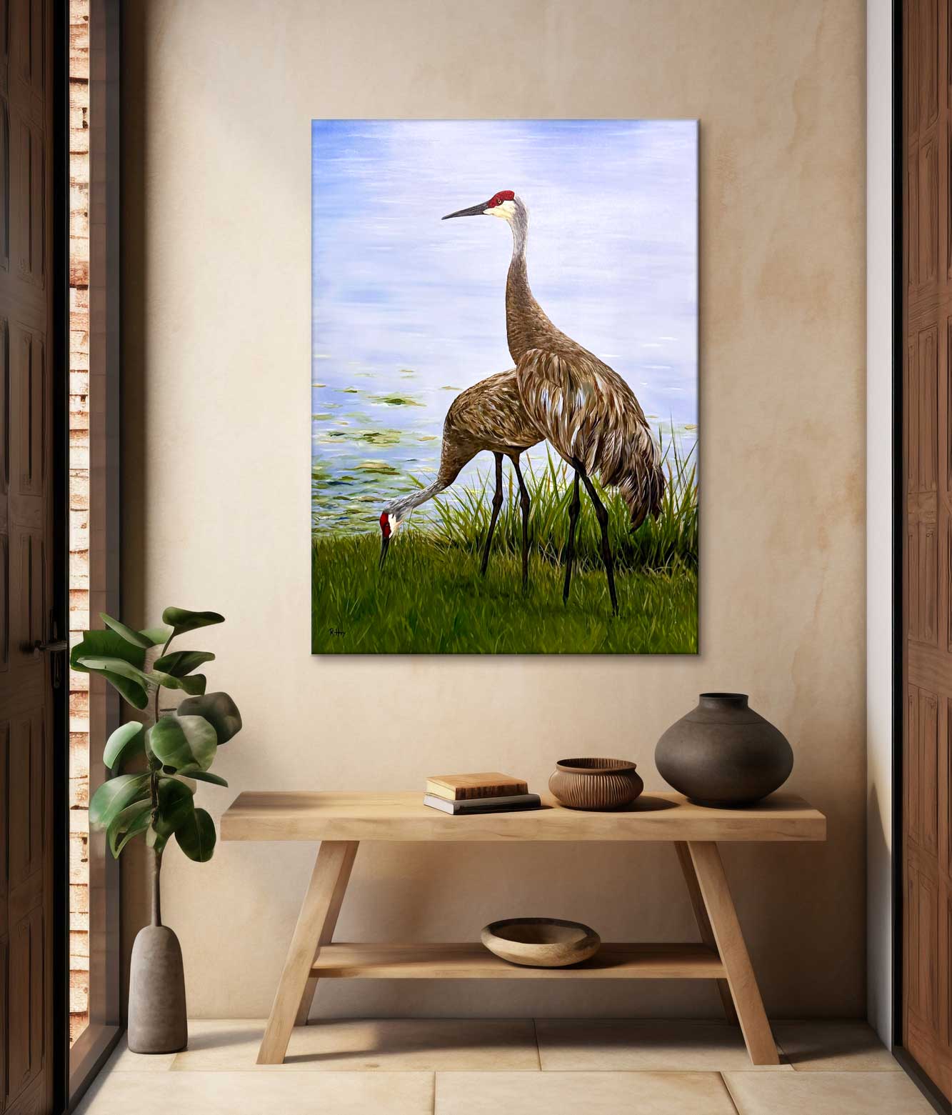 two sandhill crane birds by a waters edge